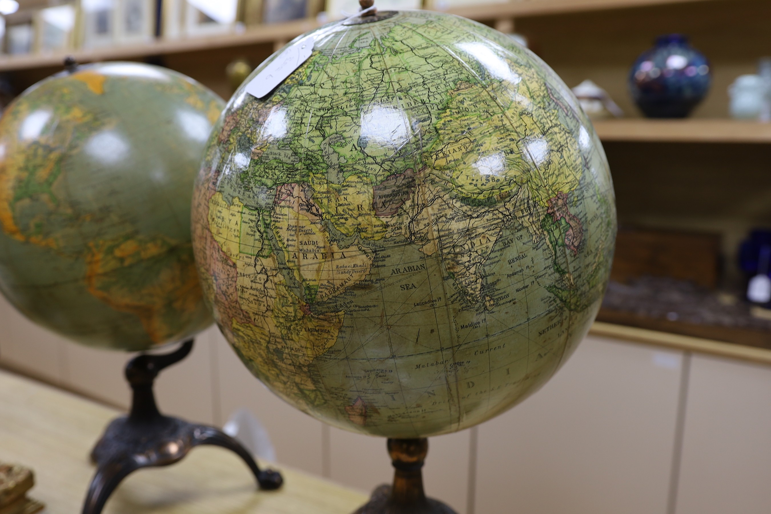 A Cartocraft USA globe on stand and another similar globe on stand, tallest 52cms high
